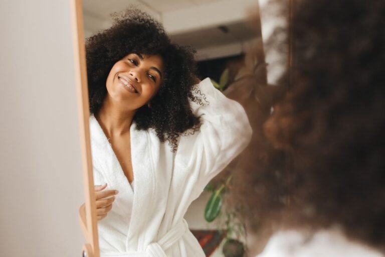 Femme souriante en peignoir chez elle