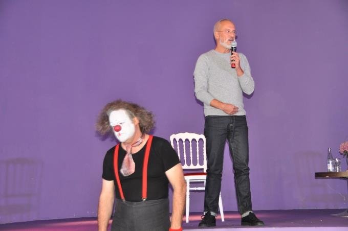 Photo d'archive d'un intervenant et d'un animateur en clown sur la scène du festival