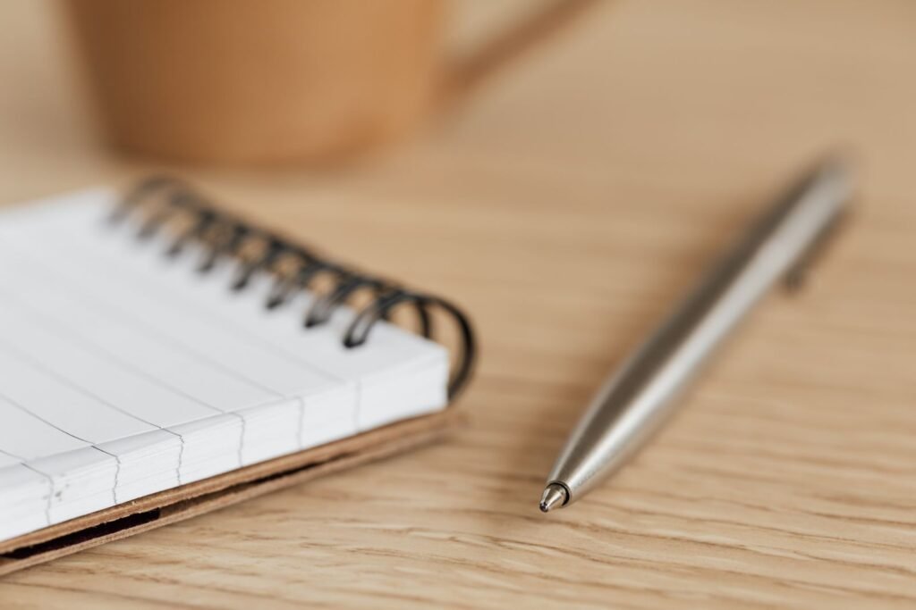Carnet et stylo posés sur un bureau en bois