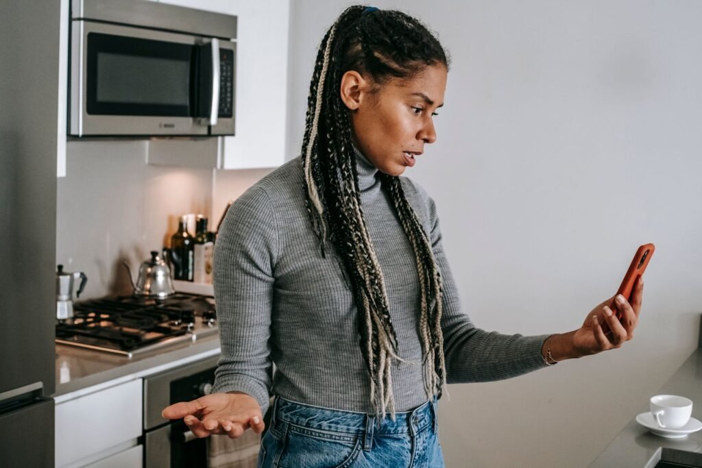 Femme qui gesticule pendant une conversation tendue au téléphone dans sa cuisine