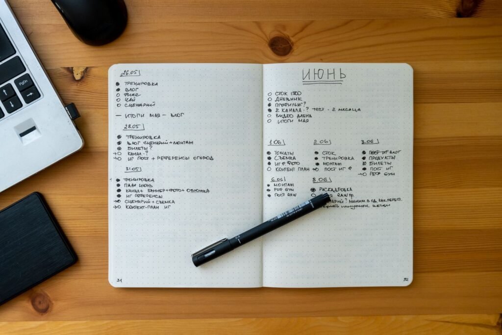 Carnet ouvert avec des notes manuscrites à côté d'un ordinateur portable
