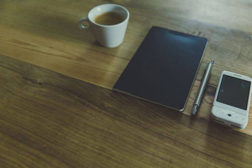Bureau simple avec une tasse de café, un carnet et un stylo