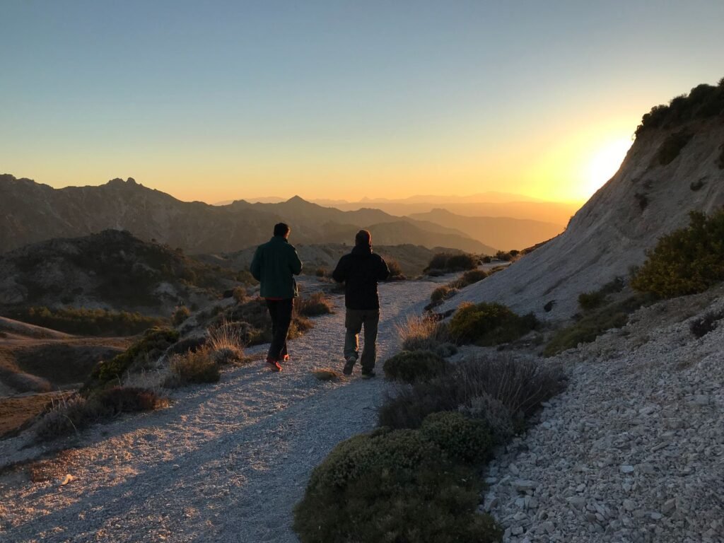 Deux randonneurs sur un chemin de montagne au lever du soleil