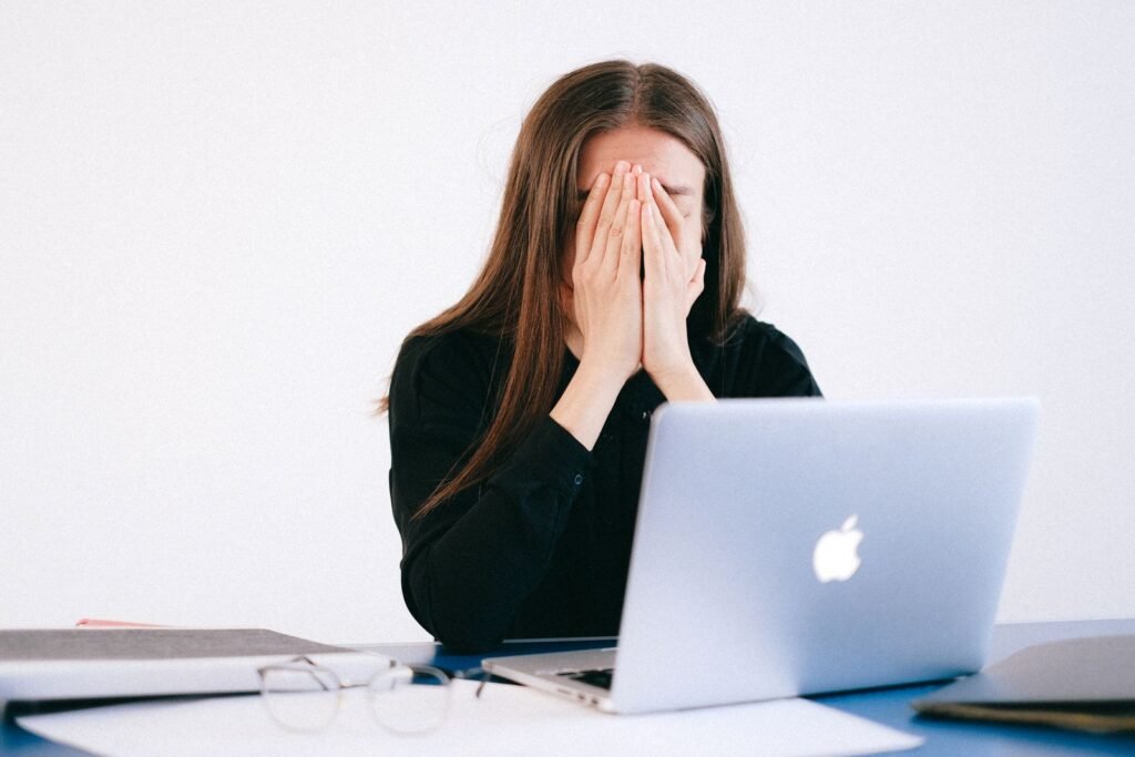 Femme débordée devant son ordinateur portable